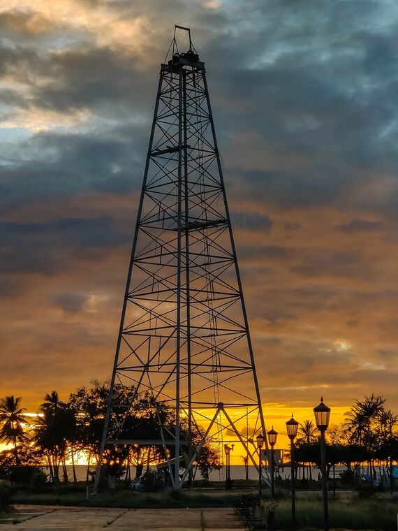 Torre petrolera recortada contra un cielo nublado al atardecer. Cabimas, Venezuela.